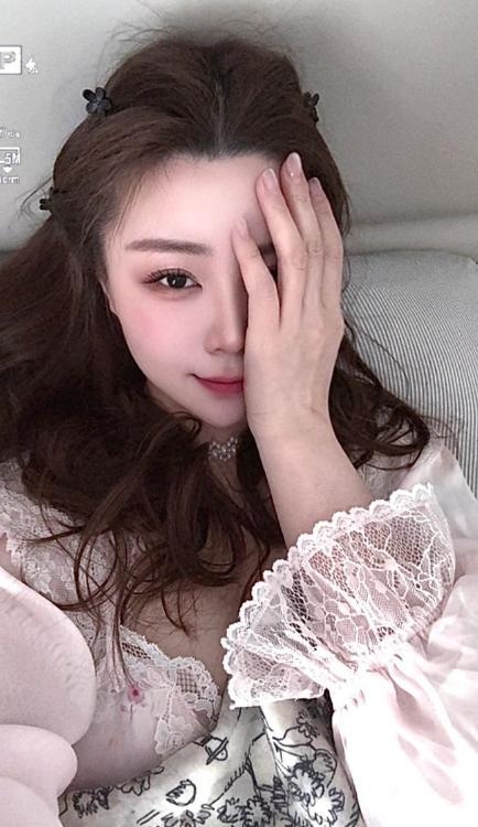 女孩侧身站立,白色吊带睡裙勾勒部与翘臀曲线